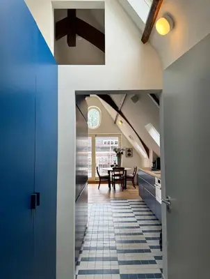 a kitchen and dining room with a blue and white tile floor at Central Art Apartment - Nieuwmarkt area in Amsterdam