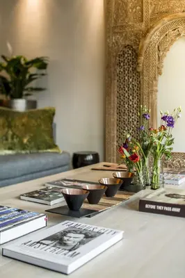 a table with bowls and books on it with flowers at KeizersgrachtSuite471 in Amsterdam
