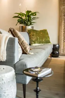 a living room with a couch with pillows and a table at KeizersgrachtSuite471 in Amsterdam