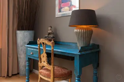a blue table with a lamp and a chair at Livia's Hideaway Canalbelt in Amsterdam