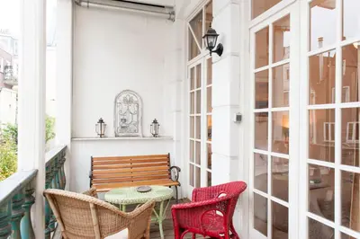 a porch with a wooden bench and two chairs at Livia's Hideaway Canalbelt in Amsterdam