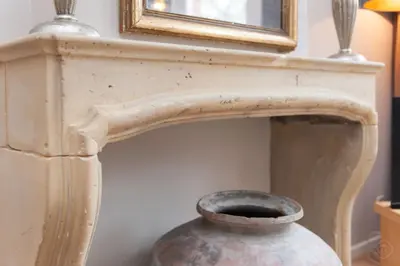a vase sitting next to a fireplace with a mirror at Livia's Hideaway Canalbelt in Amsterdam