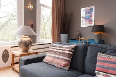 a living room with a blue couch and a window at Livia's Hideaway Canalbelt in Amsterdam