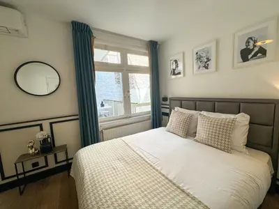 a bedroom with a large bed with a window at Yourbnb Suites Haarlemmerstraat in Amsterdam