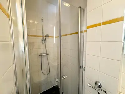 a shower with a glass door in a bathroom at Yourbnb Suites Haarlemmerstraat in Amsterdam