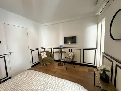 a bedroom with a bed and a table and a tv at Yourbnb Suites Haarlemmerstraat in Amsterdam