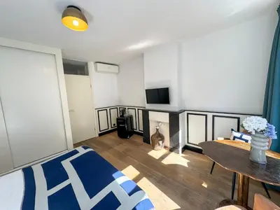a room with a bed and a table and a tv at Yourbnb Suites Haarlemmerstraat in Amsterdam