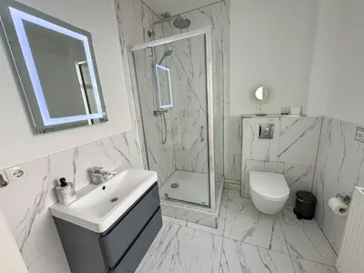 a bathroom with a sink and a shower and a toilet at Yourbnb Suites Haarlemmerstraat in Amsterdam