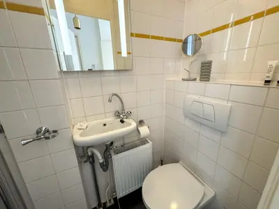 a bathroom with a toilet and a sink and a mirror at Yourbnb Suites Haarlemmerstraat in Amsterdam
