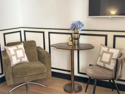 a room with two chairs and a table and a vase with flowers at Yourbnb Suites Haarlemmerstraat in Amsterdam