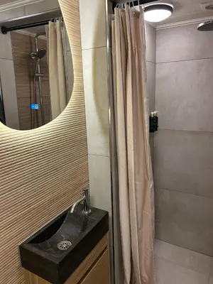a bathroom with a sink and a shower with a mirror at Westerhuysje in Uitgeest