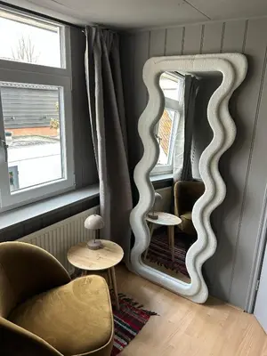 a mirror in a room with two chairs and a table at Westerhuysje in Uitgeest