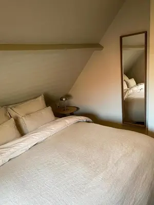a bedroom with a white bed and a mirror at Guesthouse Porter Noordwijk in Noordwijk