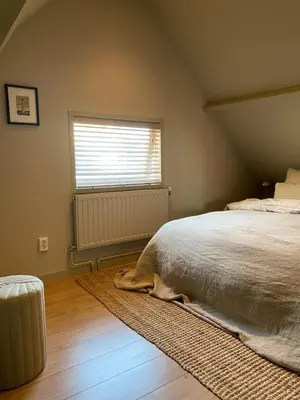 a bedroom with a bed and a window at Guesthouse Porter Noordwijk in Noordwijk