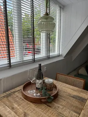 a table with a bottle of wine and two glasses at Hartje Bergen in Bergen