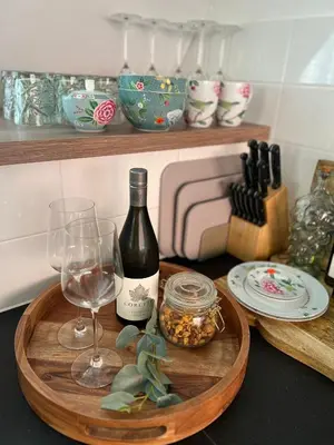 a wooden tray with a bottle of wine and a glass at Hartje Bergen in Bergen