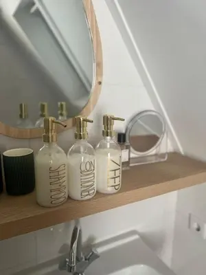 a bathroom with three soap bottles on a shelf at Hartje Bergen in Bergen