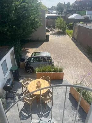 a patio with a table and chairs and a car at Hartje Bergen in Bergen