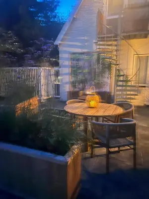 a table and chairs on a patio at night at Hartje Bergen in Bergen