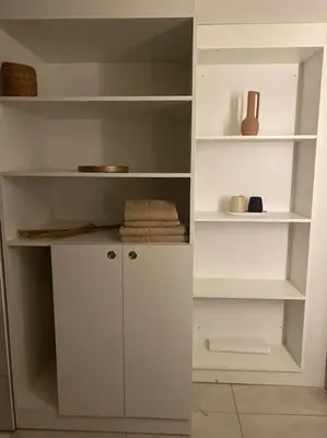 a white closet with white shelves and towels at Souterrain Sandy Sous in Noordwijk