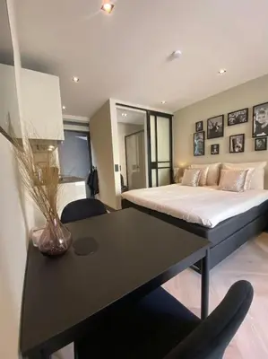 a bedroom with a bed and a table with a vase on it at Casa Wess in Zandvoort