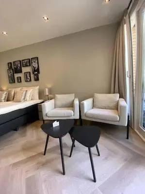 a room with a bed and two chairs and a table at Casa Wess in Zandvoort
