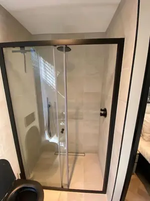 a shower with a glass door in a bathroom at Casa Wess in Zandvoort