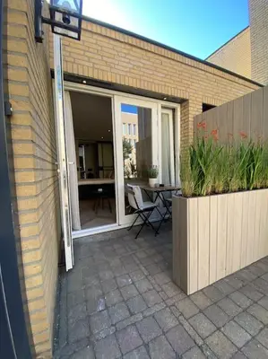 a patio with a table and a glass door at Casa Wess in Zandvoort