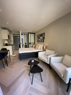 a bedroom with a bed and a couch and tables at Casa Wess in Zandvoort