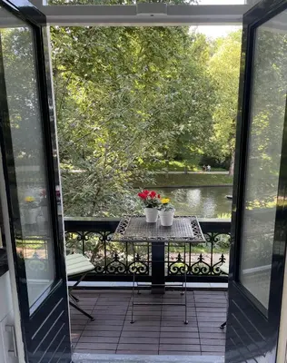 a balcony with a table with flowers on it at Bed and Breakfast Always Good in Utrecht