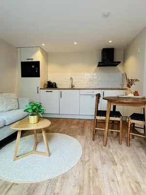 a living room with a table and a kitchen at Ocean Breeze - Noordwijk aan Zee in Noordwijk aan Zee