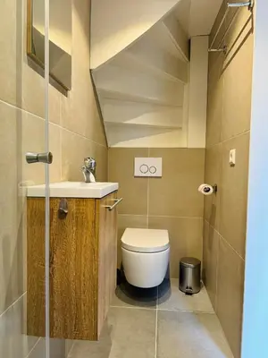 a small bathroom with a toilet and a sink at Ocean Breeze - Noordwijk aan Zee in Noordwijk aan Zee