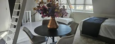 a room with a table and a vase with flowers on it at Casa Roberto in Alkmaar