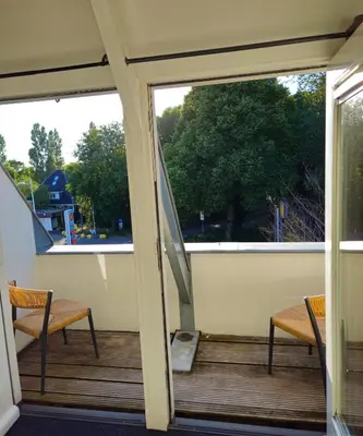 a screened porch with two chairs and a window at Casa Roberto in Alkmaar