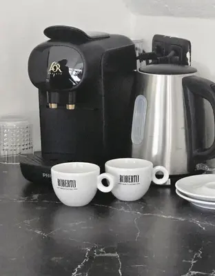 two coffee cups on a counter next to a coffee maker at Casa Roberto in Alkmaar