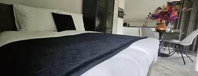 a bedroom with a bed and a table with flowers at Casa Roberto in Alkmaar