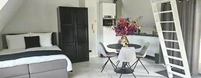 a bedroom with a bed and a table and chairs at Casa Roberto in Alkmaar
