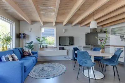 a living room with a blue couch and a table at 't Hutje centrum Uitgeest in Uitgeest