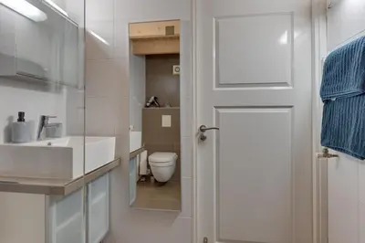 a bathroom with a toilet and a sink and a door at 't Hutje centrum Uitgeest in Uitgeest