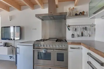a kitchen with a stainless steel stove top oven at 't Hutje centrum Uitgeest in Uitgeest