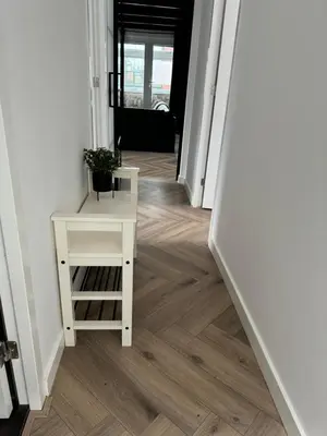 a hallway with a white table and a white stair case at Smile home 2, Zaanse schans and Amsterdam Appartements in Wormerveer