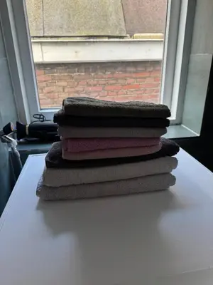 a stack of towels sitting on a table in front of a window at Smile home 2, Zaanse schans and Amsterdam Appartements in Wormerveer