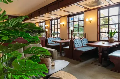 a restaurant with tables and chairs and plants at BadHotel Noordwijk in Noordwijk