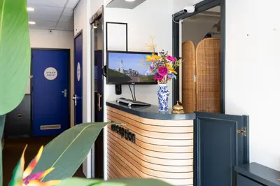 a room with a tv on a counter with flowers at BadHotel Noordwijk in Noordwijk