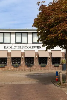 a building with a sign on the side of it at BadHotel Noordwijk in Noordwijk