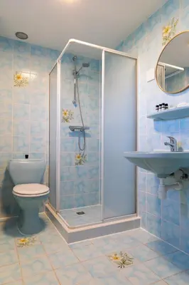 a bathroom with a shower and a toilet and a sink at BadHotel Noordwijk in Noordwijk