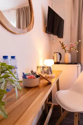 a room with a desk with a lamp and a mirror at BadHotel Noordwijk in Noordwijk