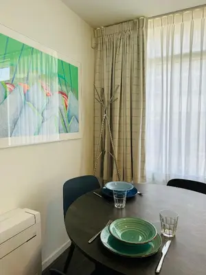 a dining room table with green plates on it at Beachhouse Seepaertje - Boulevard Noordwijk aan Zee in Noordwijk aan Zee