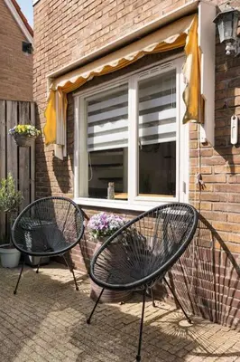 two black chairs sitting in front of a window at Hello Noordwijk - Quarles 43 in Noordwijk aan Zee