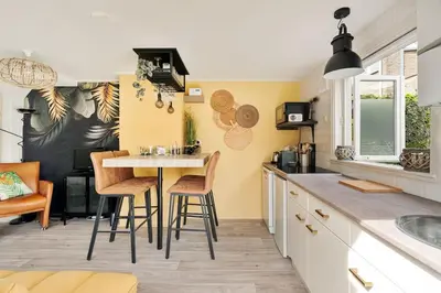 a kitchen with a table and chairs in a room at Hello Noordwijk - Quarles 43 in Noordwijk aan Zee